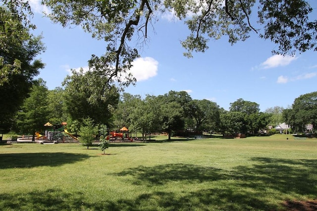 view of home's community featuring a playground and a lawn