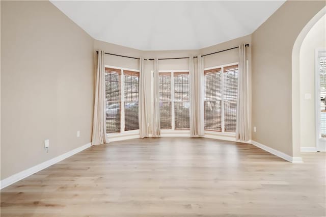 unfurnished room with lofted ceiling and light hardwood / wood-style floors