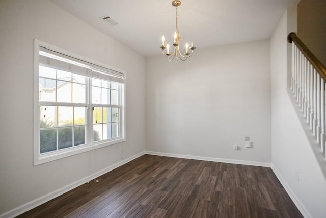 spare room featuring dark wood finished floors, visible vents, and baseboards