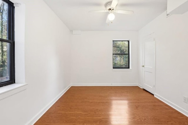 unfurnished room featuring a ceiling fan, baseboards, and wood finished floors