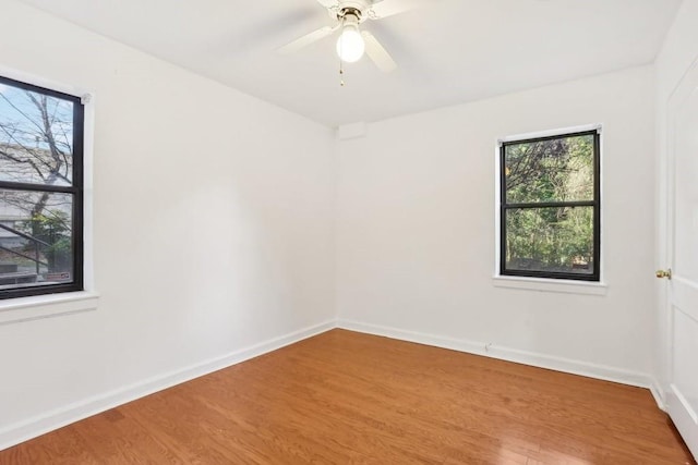 spare room with ceiling fan, baseboards, and wood finished floors