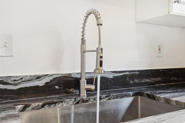 room details featuring white cabinetry and a sink