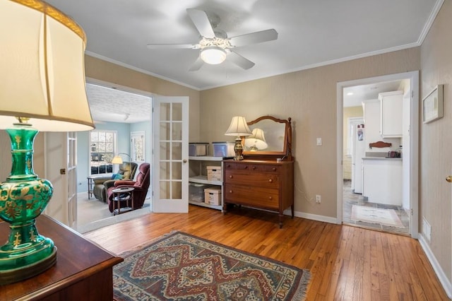 living area with crown molding, light hardwood / wood-style flooring, french doors, and ceiling fan