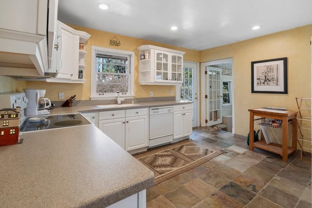 kitchen featuring white dishwasher, sink, stove, and white cabinets