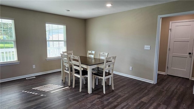 dining room with dark wood-style flooring, baseboards, and plenty of natural light