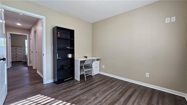 unfurnished office with dark wood-style flooring and baseboards