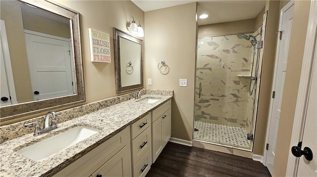 full bathroom featuring a sink, a stall shower, and wood finished floors