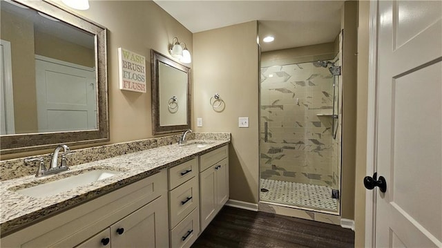 full bathroom with a shower stall, wood finished floors, and a sink