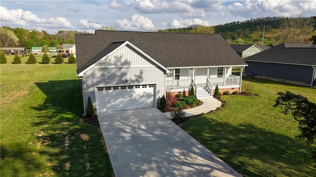 view of front of property featuring a shingled roof, an attached garage, covered porch, concrete driveway, and a front lawn