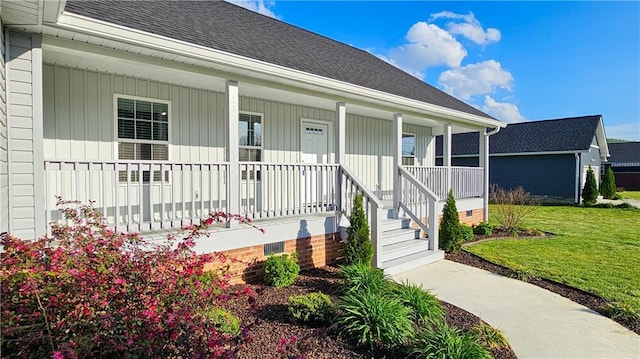 doorway to property featuring a shingled roof, covered porch, crawl space, a lawn, and board and batten siding