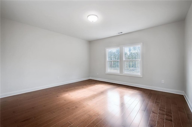 unfurnished room with dark hardwood / wood-style flooring