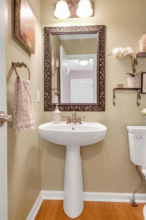 bathroom with sink, wood-type flooring, and toilet