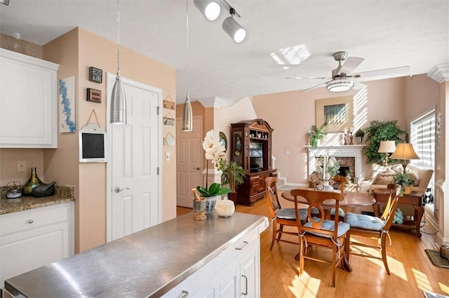 kitchen featuring white cabinets, ceiling fan, and light hardwood / wood-style floors