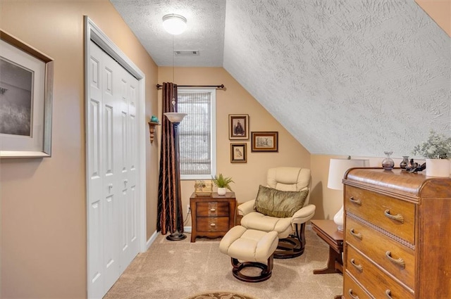 living area featuring a textured ceiling, light colored carpet, and vaulted ceiling