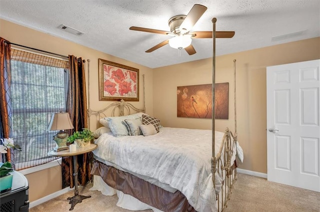 carpeted bedroom with ceiling fan and a textured ceiling