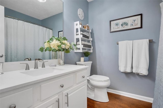 bathroom with hardwood / wood-style flooring, vanity, and toilet