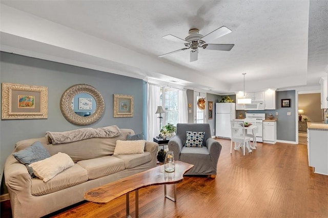 living room featuring ceiling fan and light hardwood / wood-style floors