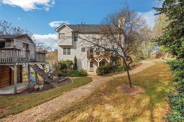 back of house with a deck and a lawn