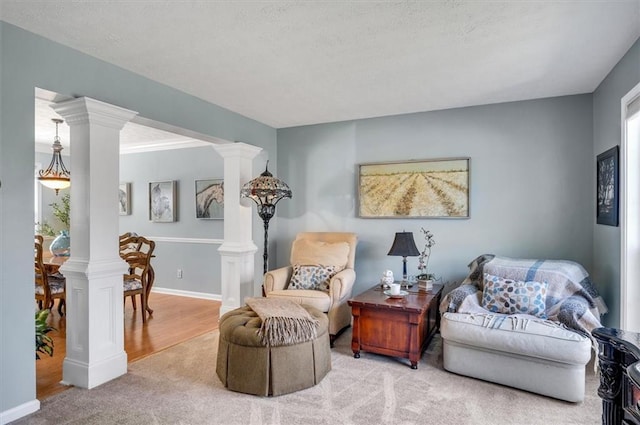 living area featuring carpet and decorative columns