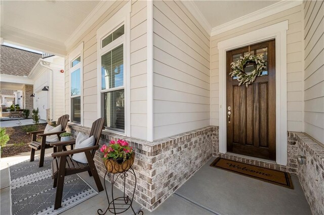 doorway to property featuring brick siding and a porch