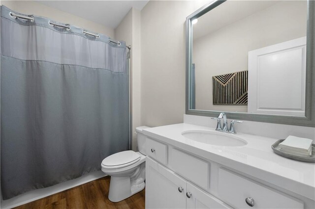 full bathroom featuring toilet, vanity, a shower with shower curtain, and wood finished floors