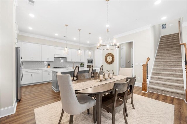 dining room with dark wood finished floors, stairs, a notable chandelier, and crown molding