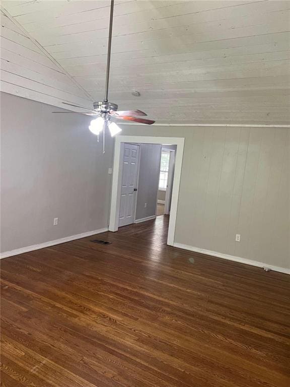 unfurnished room with wood ceiling, dark hardwood / wood-style floors, vaulted ceiling, ceiling fan, and wood walls