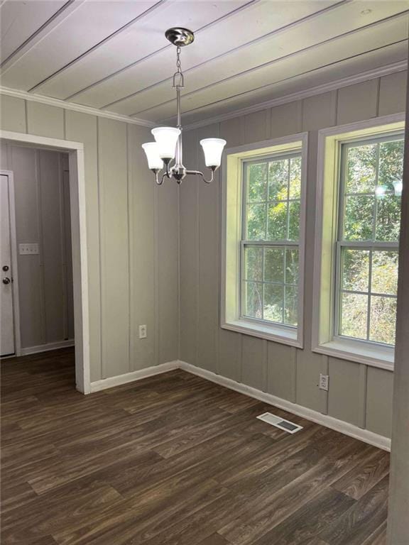 unfurnished dining area featuring an inviting chandelier, plenty of natural light, and dark hardwood / wood-style flooring