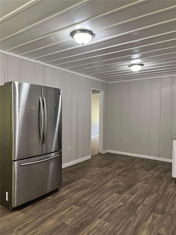 kitchen with dark hardwood / wood-style floors, stainless steel appliances, crown molding, light stone countertops, and white cabinets