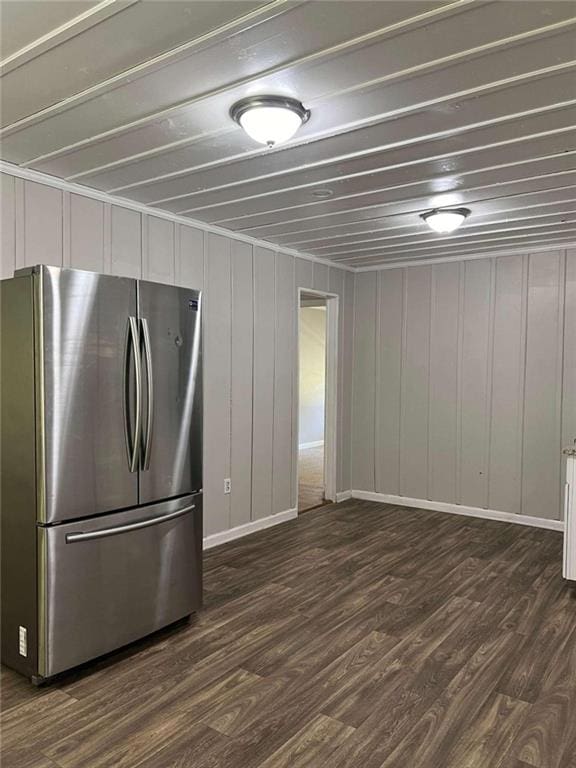 kitchen featuring dark wood-type flooring, freestanding refrigerator, white cabinetry, and baseboards