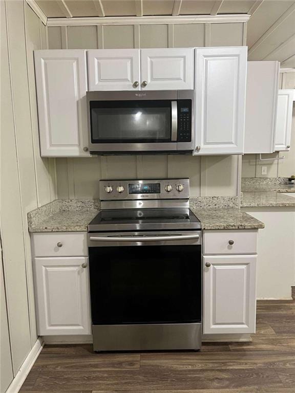 kitchen featuring white cabinetry, stainless steel appliances, dark wood-type flooring, and light stone counters