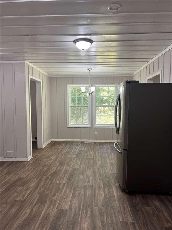 interior space with dark wood-style floors, freestanding refrigerator, a chandelier, and baseboards