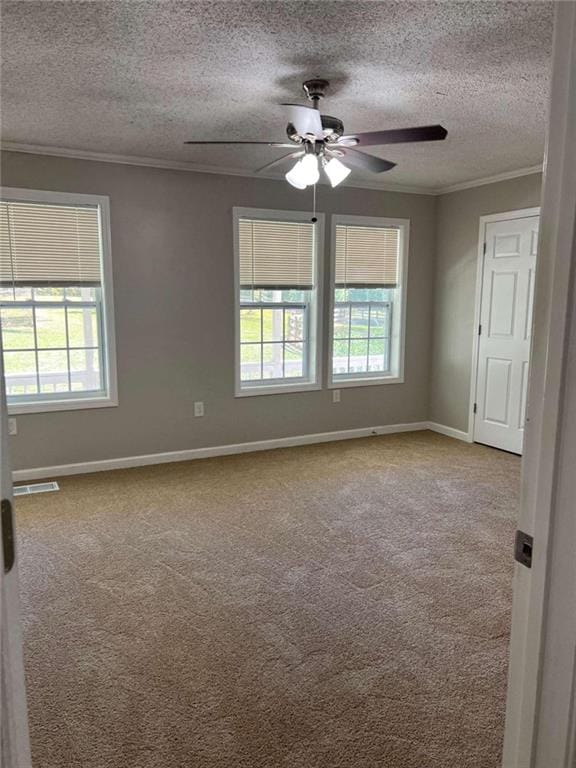 carpeted empty room with ornamental molding, a textured ceiling, and ceiling fan