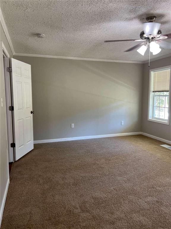 empty room featuring crown molding, a textured ceiling, dark carpet, and ceiling fan