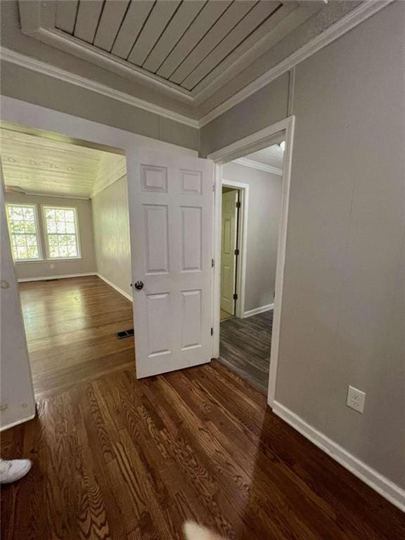 spare room with crown molding and dark wood-type flooring