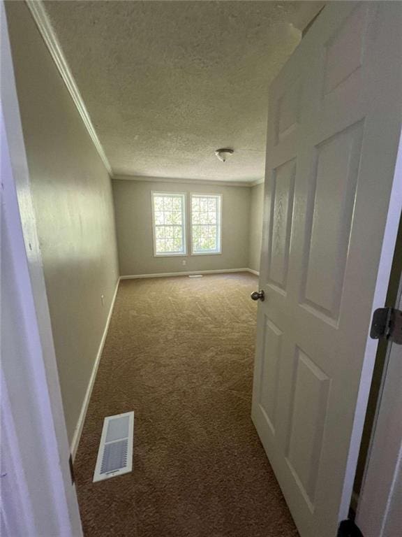 carpeted empty room featuring crown molding and a textured ceiling