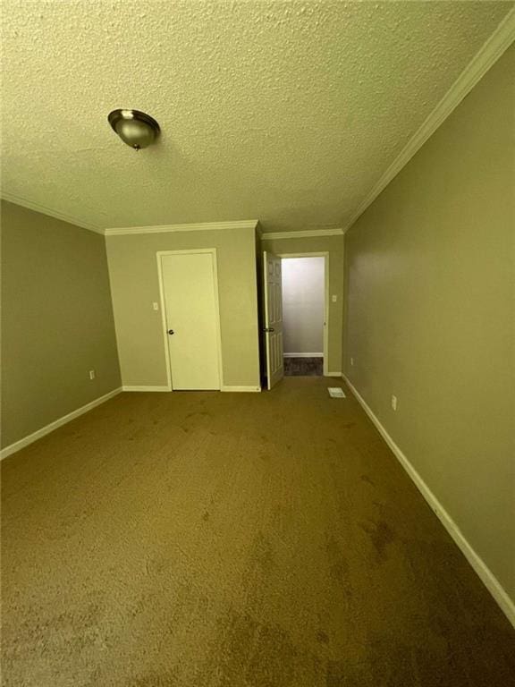 unfurnished bedroom with a textured ceiling, ornamental molding, carpet, and baseboards