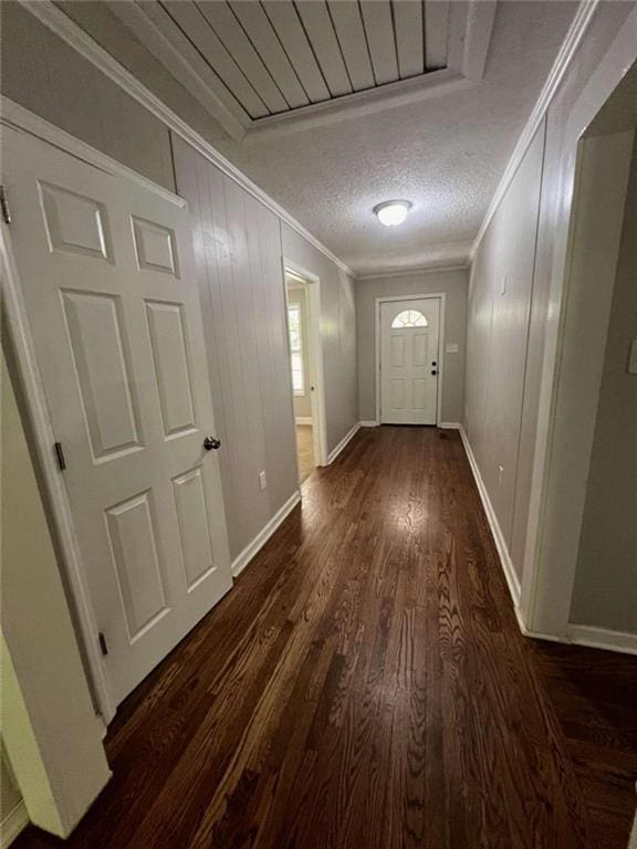 doorway featuring ornamental molding, a textured ceiling, and dark wood-type flooring