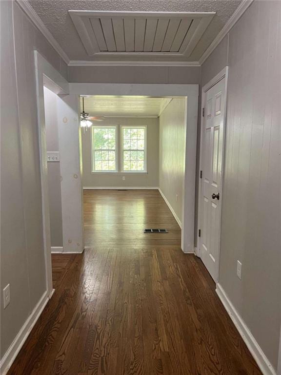 corridor featuring crown molding, a textured ceiling, and dark hardwood / wood-style flooring