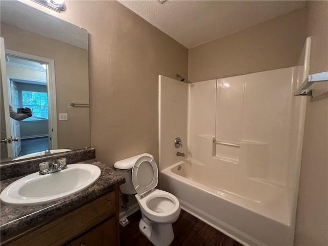 full bathroom featuring bathing tub / shower combination, vanity, a textured ceiling, hardwood / wood-style flooring, and toilet