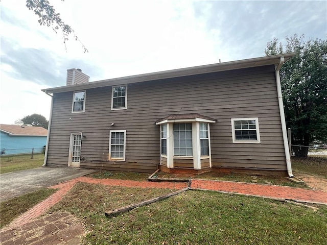 back of house with a lawn and a patio area