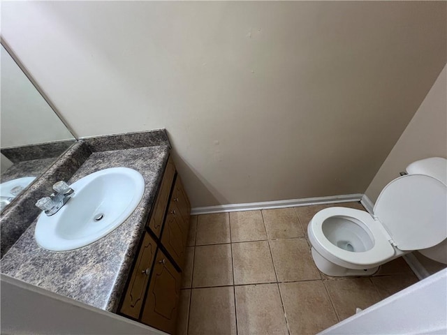 bathroom with toilet, vanity, and tile patterned flooring