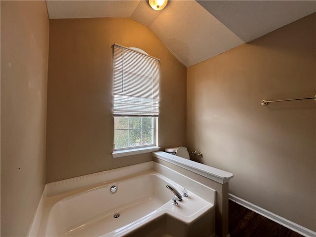 bathroom featuring lofted ceiling, a tub, and wood-type flooring