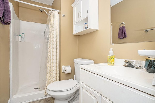 bathroom with toilet, a shower stall, and vanity