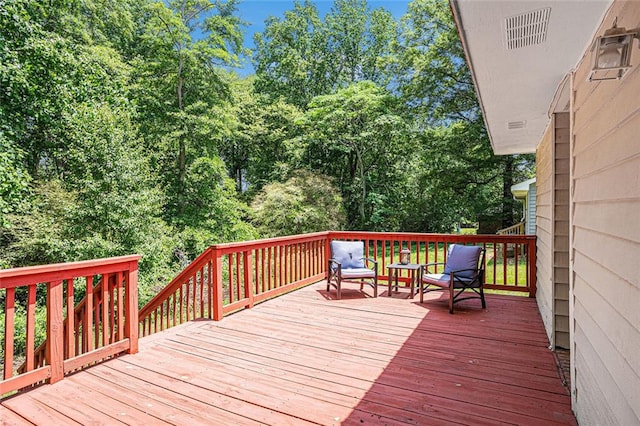wooden terrace with view of wooded area