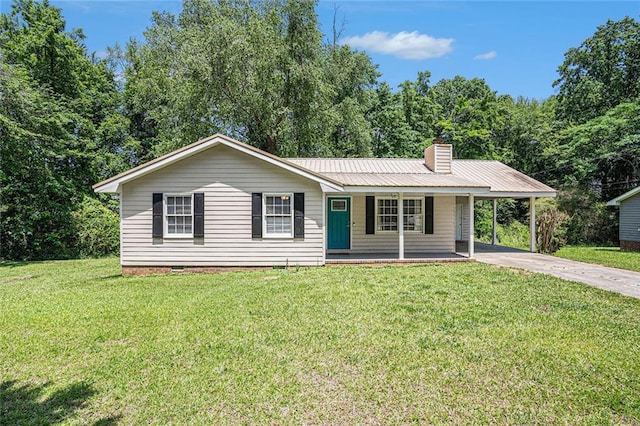 single story home with concrete driveway, an attached carport, a porch, a front yard, and metal roof