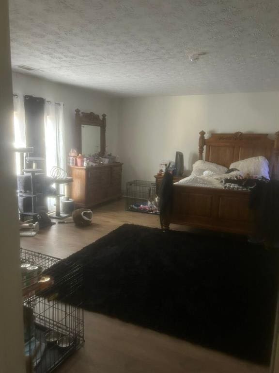 bedroom featuring wood-type flooring and a textured ceiling