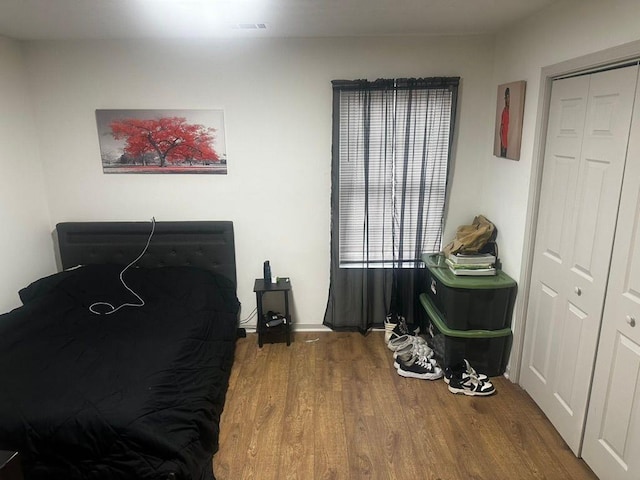 bedroom with wood-type flooring and a closet