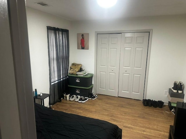 bedroom with light hardwood / wood-style floors and a closet