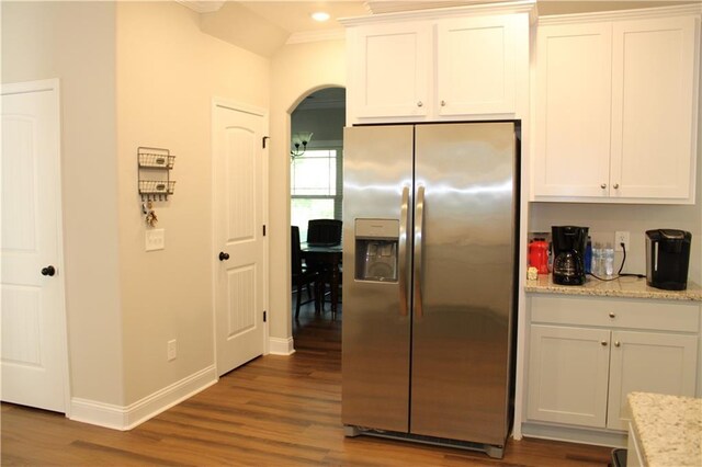 2647 Old Snapping Shoals Rd, Mcdonough, GA 30252 - kitchen with stainless steel fridge, arched walkways, wood finished floors, baseboards, and white cabinets